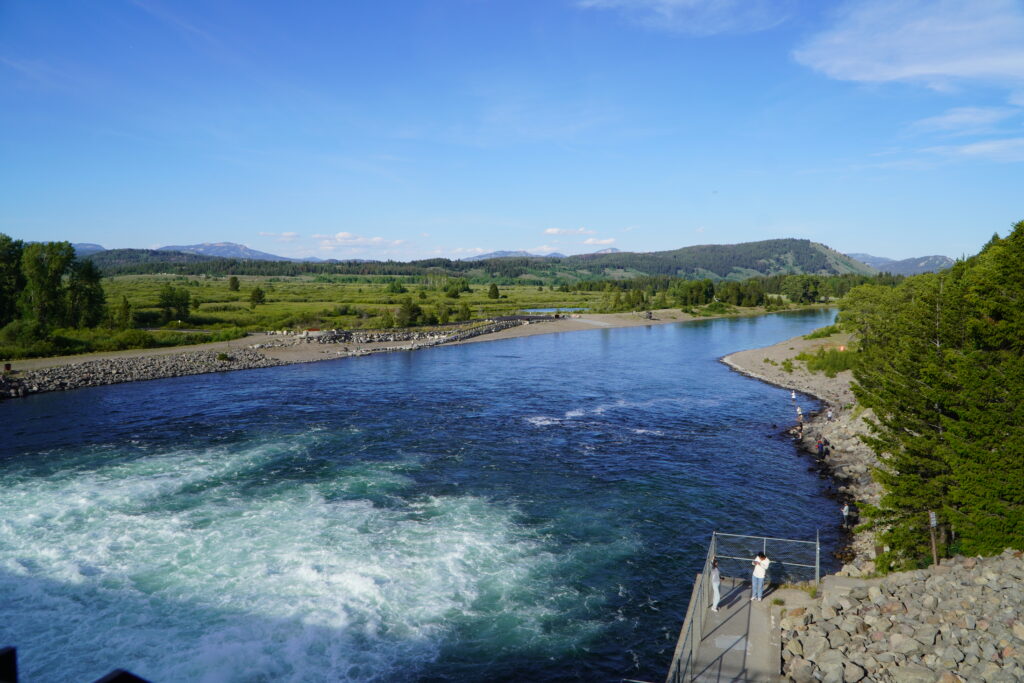 Widok na zapaporę Jackson Lake Dam i góry Grand Teton w tle.